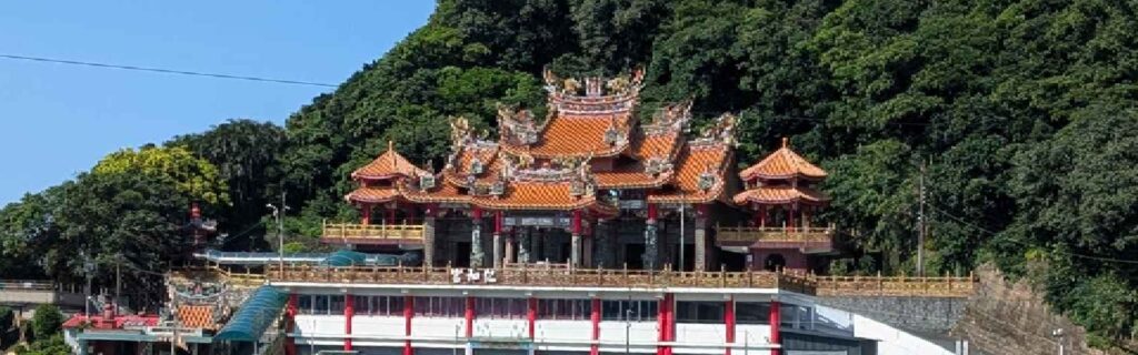 A closeup of an ornate temple with orange tile roofs and dragon sculptures