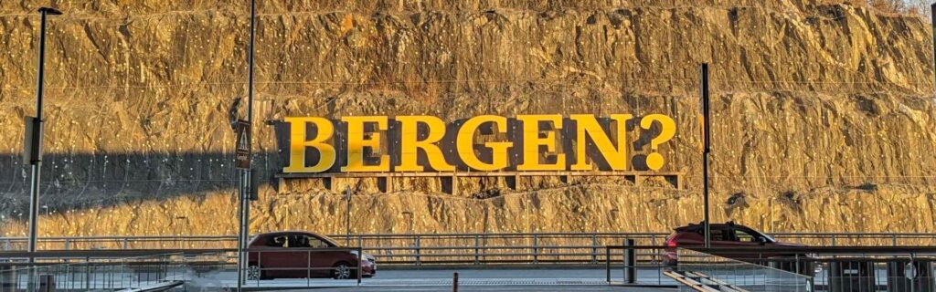 Bright yellow Bergen sign on a cliff face