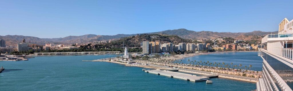 Panoramic view of Málaga’s waterfront with palm-lined walkway and cruise ship in the foreground