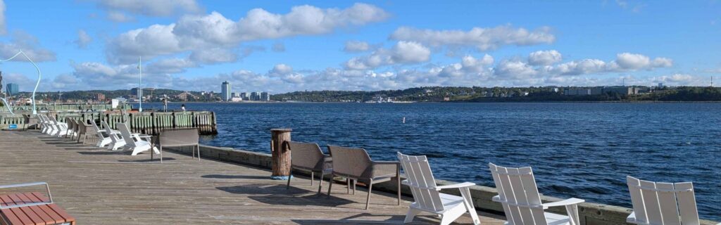 Chairs facing Halifax Harbour along wooden boardwalk