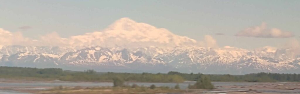 Distant view of Mount Denali rising above surrounding landscape