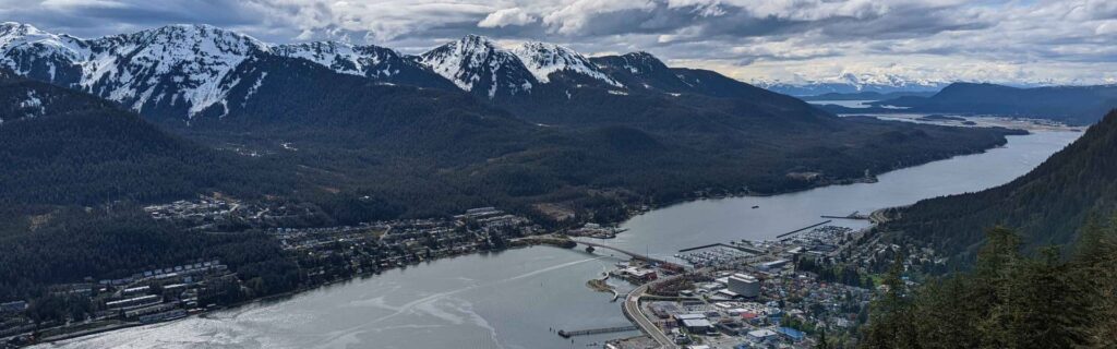 Wide panoramic view of Juneau harbor and snow covered mountains