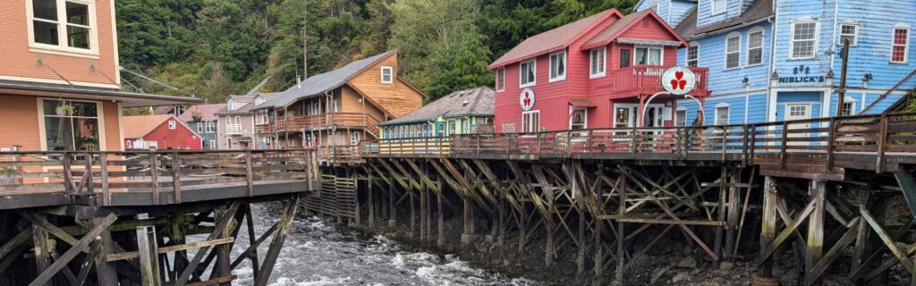 Colorful buildings on stilts line Creek Street above rushing water in Ketchikan