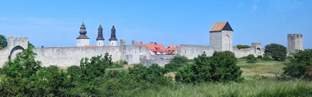 Panoramic view of the Visby Ringmur and medieval towers under bright summer skies.