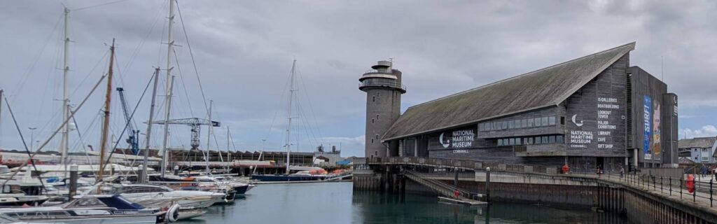 National Maritime Museum Cornwall and marina waterfront beneath dramatic clouds in Falmouth
